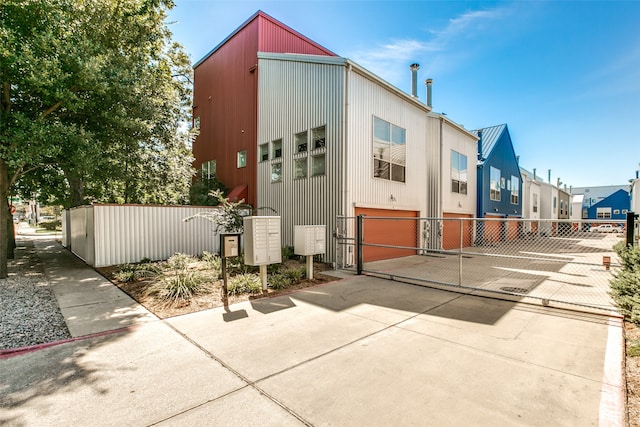 exterior space featuring driveway, a garage, and fence