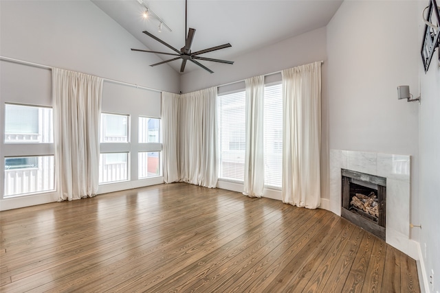 unfurnished living room featuring hardwood / wood-style flooring, a healthy amount of sunlight, and track lighting