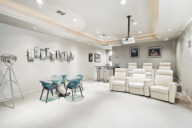 carpeted home theater room with a raised ceiling