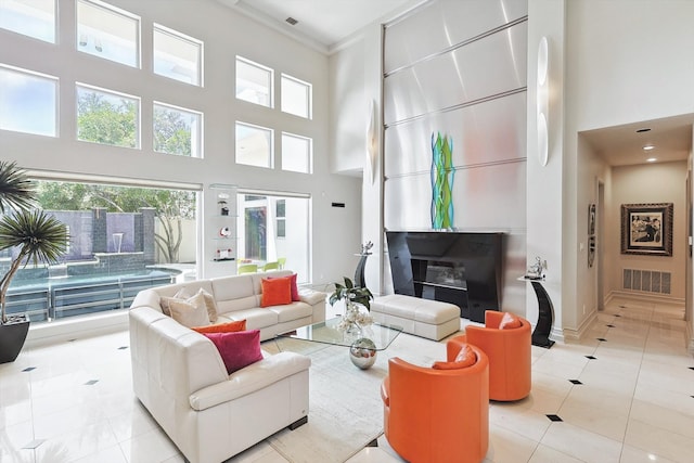 tiled living room with crown molding and a towering ceiling