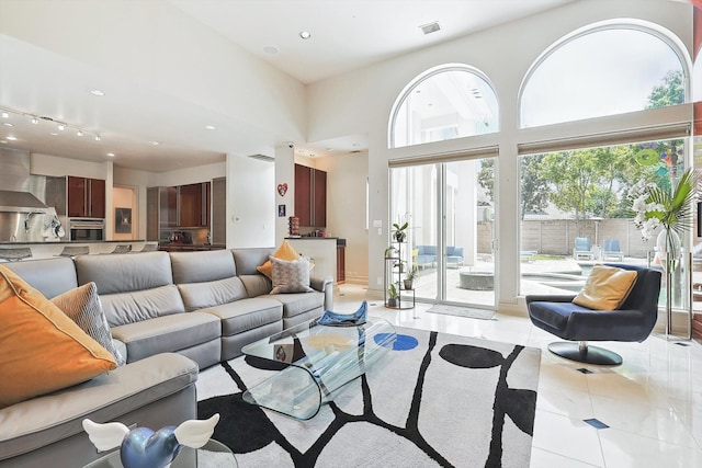 living room with a high ceiling and light tile patterned floors