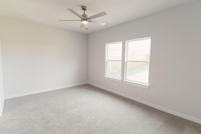 carpeted empty room featuring ceiling fan and a healthy amount of sunlight