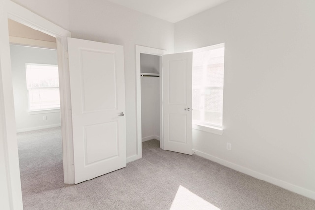 unfurnished bedroom featuring light colored carpet and a closet