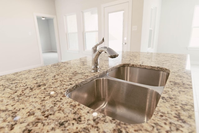 details featuring light stone counters and sink