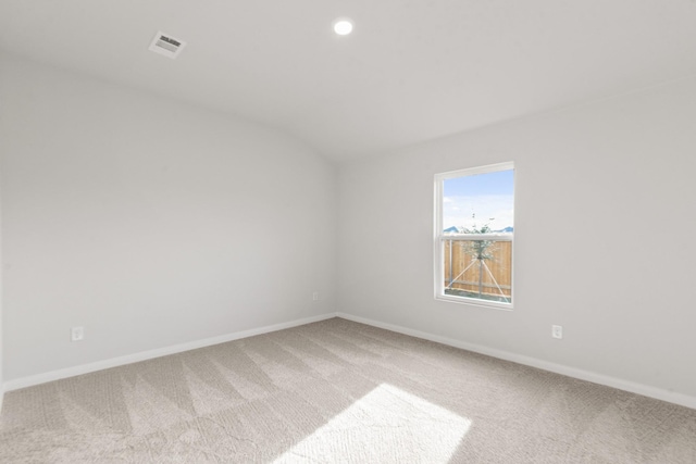 carpeted spare room with lofted ceiling