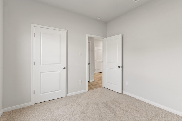 unfurnished bedroom featuring light carpet