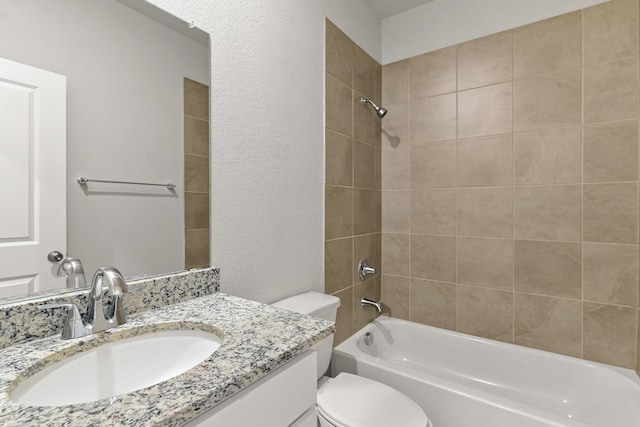 full bathroom with tiled shower / bath, vanity, and toilet