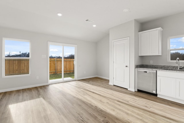 kitchen with light stone countertops, sink, stainless steel dishwasher, and white cabinets