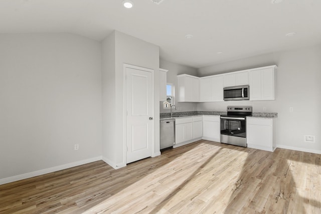 kitchen featuring sink, white cabinets, light stone counters, light hardwood / wood-style floors, and stainless steel appliances