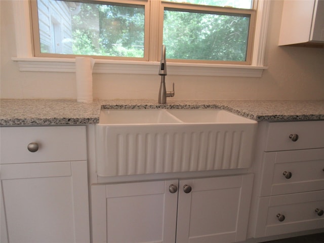 kitchen with white cabinets, sink, and a wealth of natural light