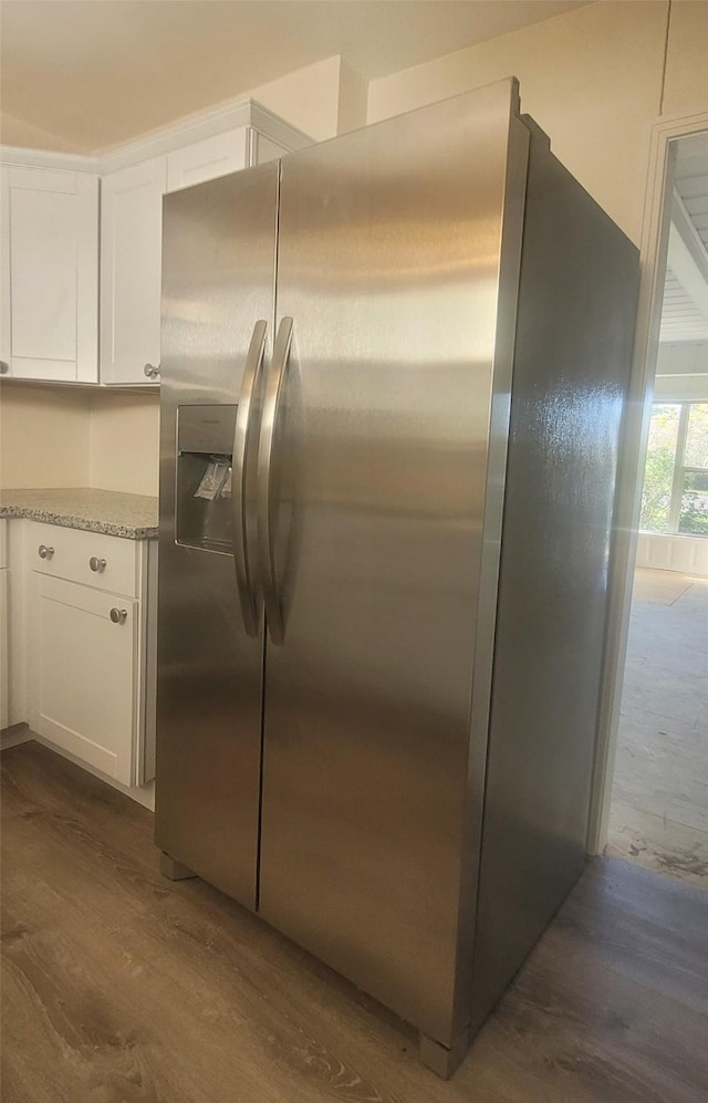 kitchen featuring light stone countertops, white cabinets, dark wood-type flooring, and stainless steel refrigerator with ice dispenser