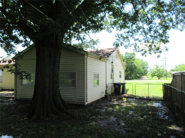 view of property exterior with a lawn and cooling unit