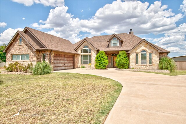 view of front of house featuring a garage and a front lawn