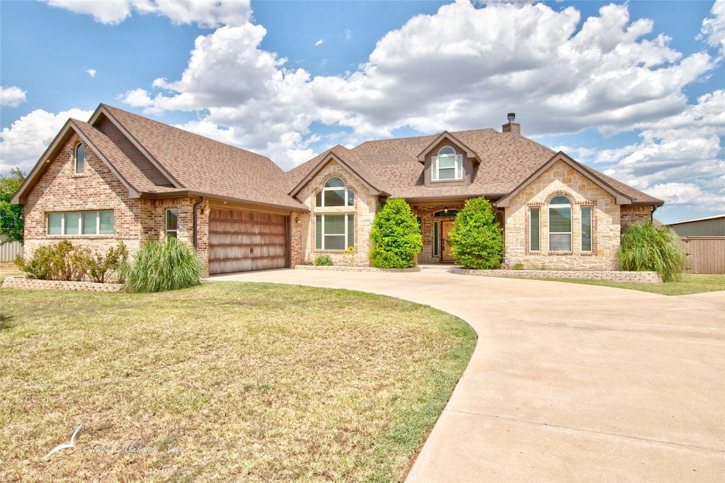 view of front of house featuring a garage and a front lawn