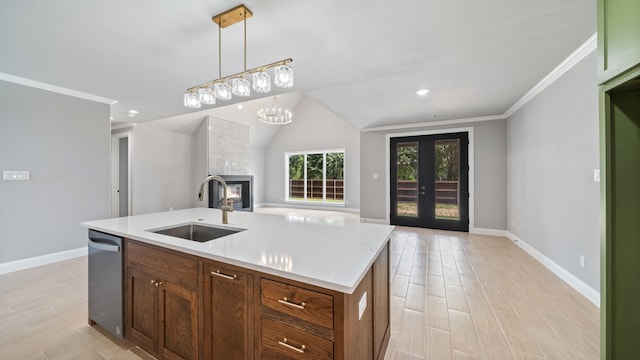 kitchen featuring a fireplace, an island with sink, sink, dishwasher, and light hardwood / wood-style flooring