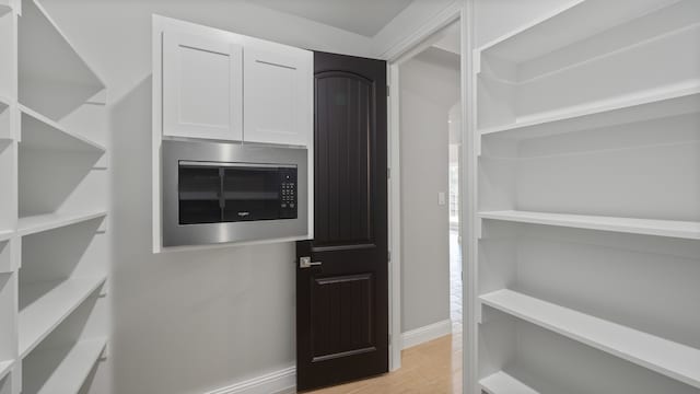 walk in closet with light wood-type flooring