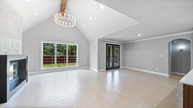 unfurnished living room with light hardwood / wood-style flooring, french doors, an inviting chandelier, beamed ceiling, and a stone fireplace