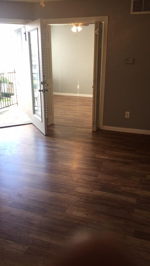 empty room featuring ceiling fan and dark wood-type flooring