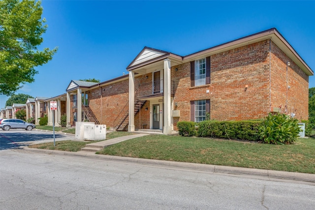 view of front of home with a balcony and a front lawn