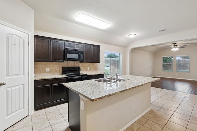 kitchen featuring black appliances, decorative backsplash, sink, light hardwood / wood-style floors, and lofted ceiling