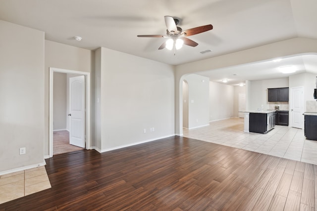 unfurnished living room featuring sink, tile patterned flooring, ceiling fan, and lofted ceiling