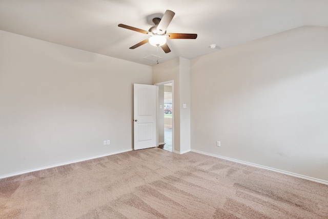 carpeted spare room with ceiling fan and vaulted ceiling