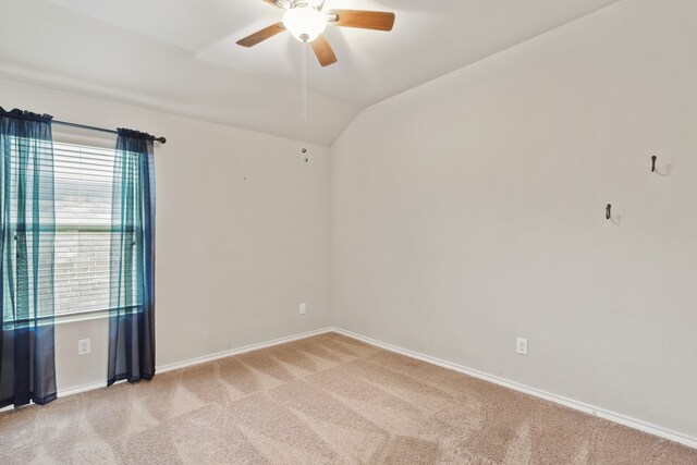 carpeted spare room featuring ceiling fan and vaulted ceiling