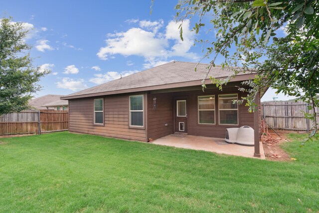 rear view of property with a lawn and a patio area