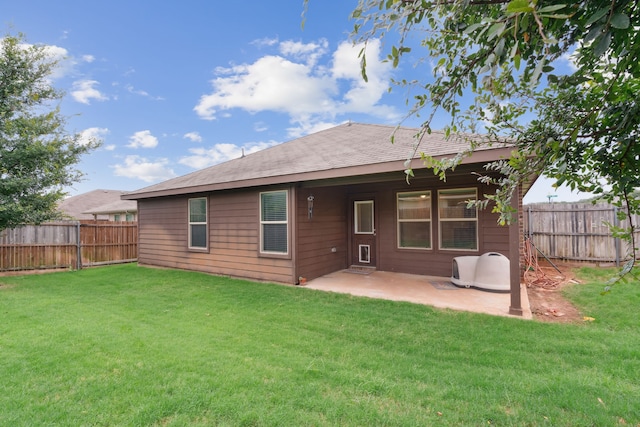 rear view of property featuring a yard and a patio