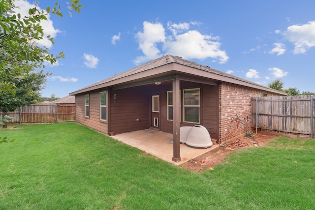 back of property with a patio area and a lawn