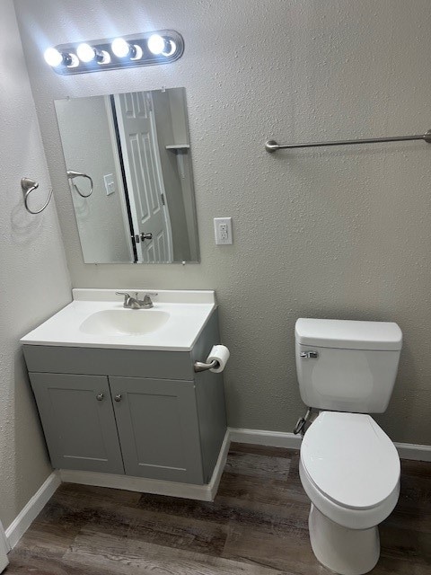 bathroom featuring vanity, toilet, and hardwood / wood-style floors