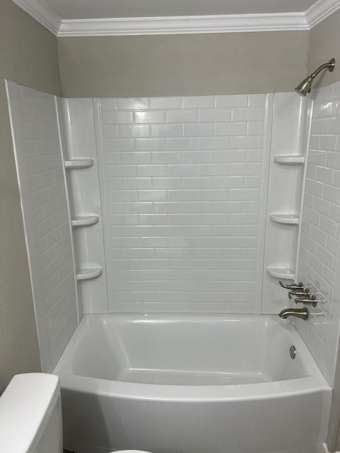 bathroom featuring crown molding, shower / washtub combination, and toilet