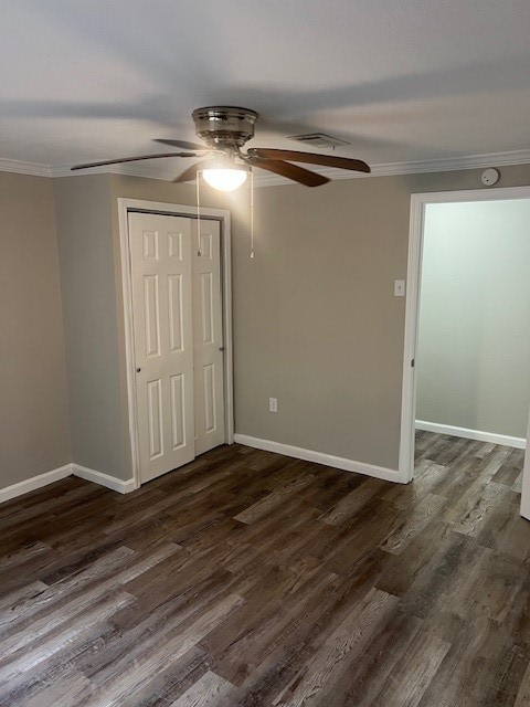 spare room with dark hardwood / wood-style flooring, ornamental molding, and ceiling fan