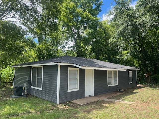 view of outbuilding featuring cooling unit and a yard