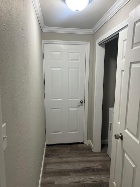 hallway featuring ornamental molding, dark hardwood / wood-style flooring, and washer / dryer