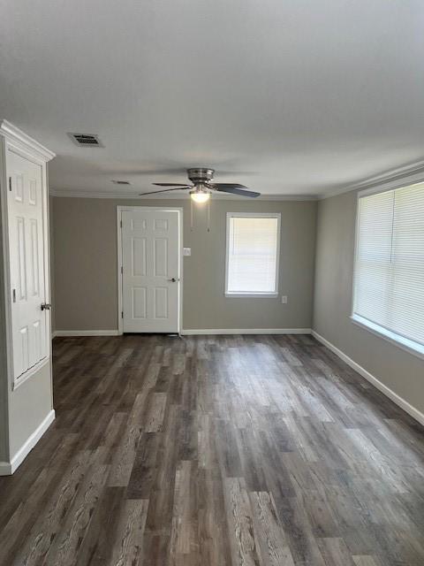 spare room with dark hardwood / wood-style floors, crown molding, and ceiling fan