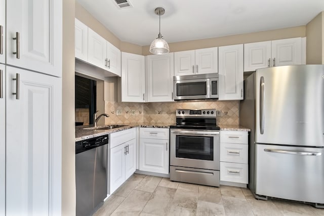 kitchen featuring stainless steel appliances, backsplash, hanging light fixtures, and sink