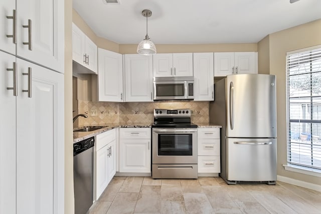 kitchen with pendant lighting, a healthy amount of sunlight, appliances with stainless steel finishes, and sink