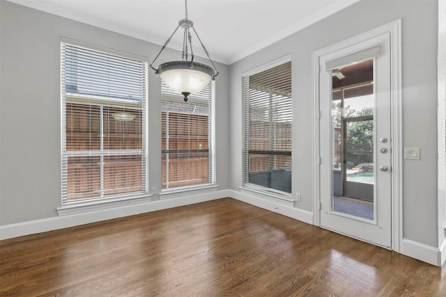 unfurnished dining area featuring dark hardwood / wood-style floors and crown molding