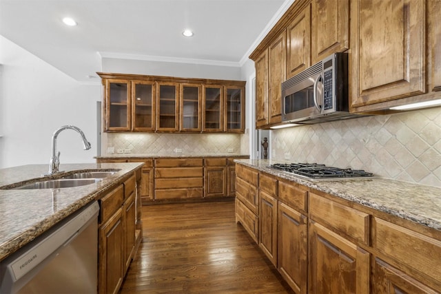 kitchen featuring light stone countertops, stainless steel appliances, crown molding, sink, and dark hardwood / wood-style floors