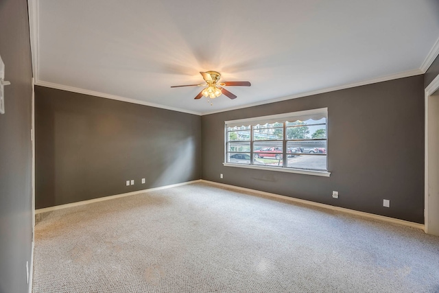 carpeted spare room featuring ceiling fan and crown molding