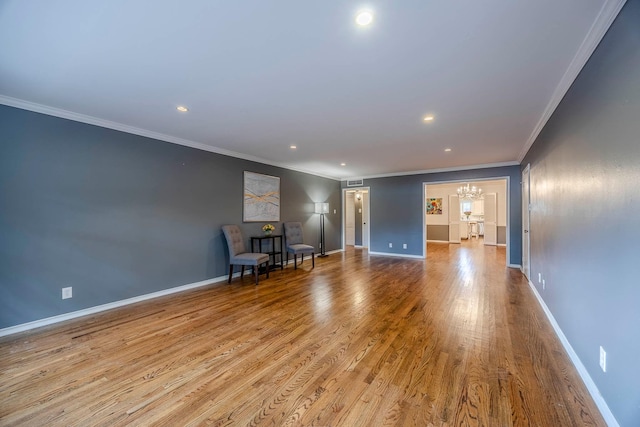 interior space featuring light wood-type flooring, ornamental molding, and a notable chandelier