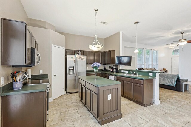 kitchen featuring a center island, ceiling fan, hanging light fixtures, appliances with stainless steel finishes, and dark brown cabinetry