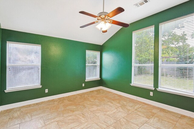 tiled empty room featuring lofted ceiling and ceiling fan