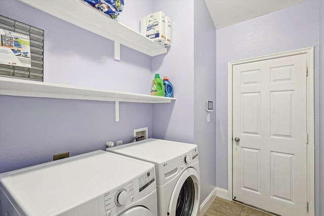 washroom featuring independent washer and dryer and light tile patterned floors