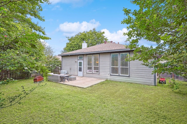 rear view of house featuring a yard and a patio