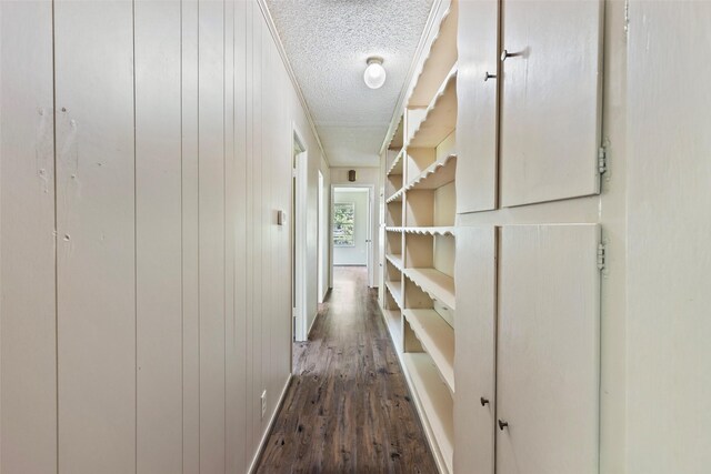 hallway with dark hardwood / wood-style flooring and a textured ceiling