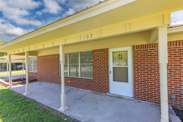 view of exterior entry featuring brick siding