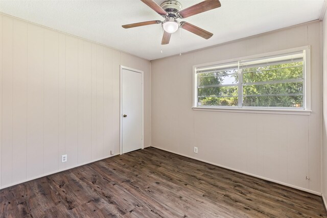 unfurnished room with ceiling fan and dark wood-type flooring