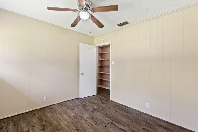 unfurnished room featuring a textured ceiling, ceiling fan, and dark wood-type flooring